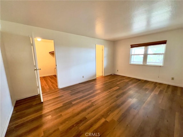 unfurnished room with dark wood-type flooring