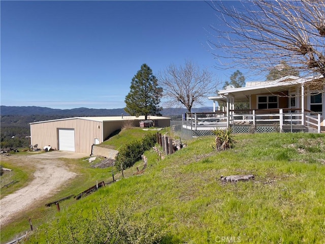 view of yard featuring a garage, an outdoor structure, and a mountain view