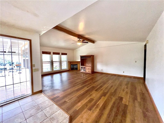 unfurnished living room with ceiling fan, lofted ceiling with beams, and light hardwood / wood-style flooring