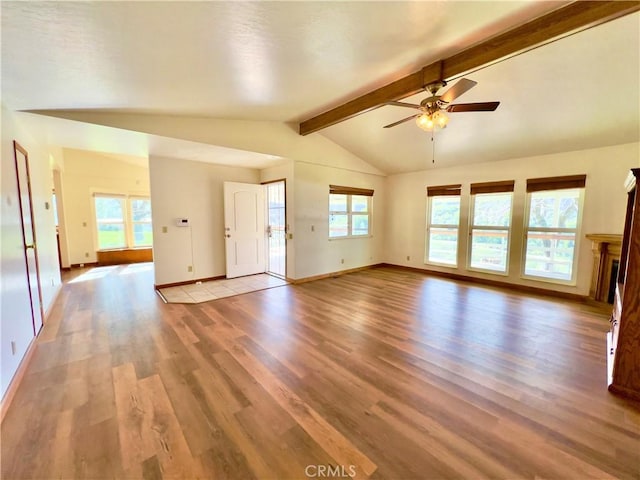 unfurnished living room with ceiling fan, vaulted ceiling with beams, and light wood-type flooring