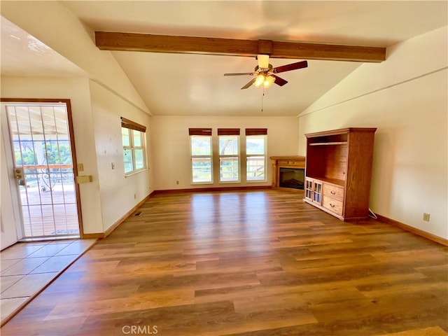 unfurnished living room featuring ceiling fan, dark hardwood / wood-style floors, and vaulted ceiling with beams