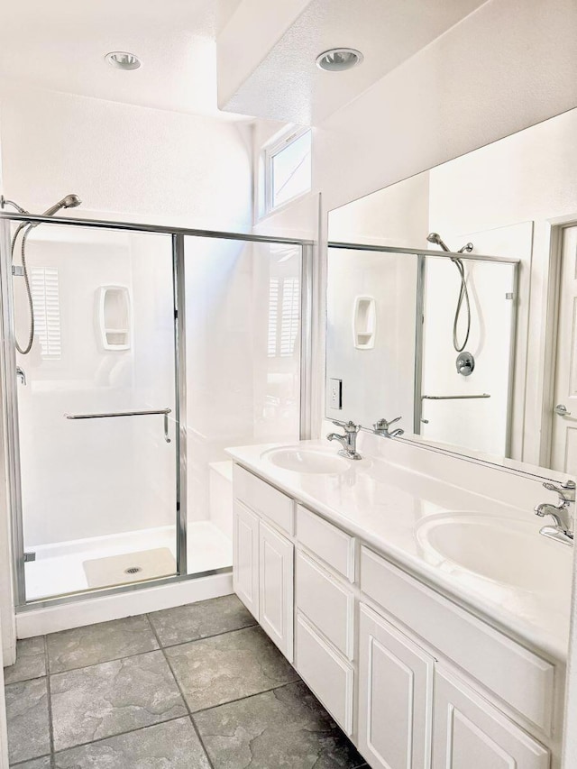 bathroom with vanity and a shower with door