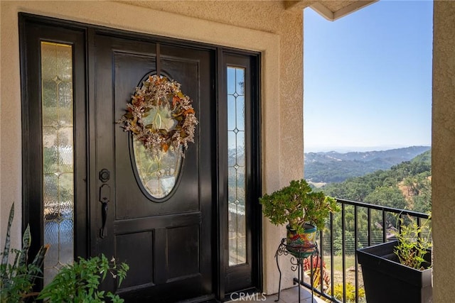 doorway to property featuring a mountain view and a balcony