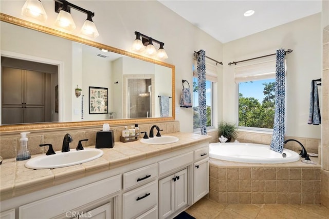 bathroom with tile patterned floors, vanity, and independent shower and bath