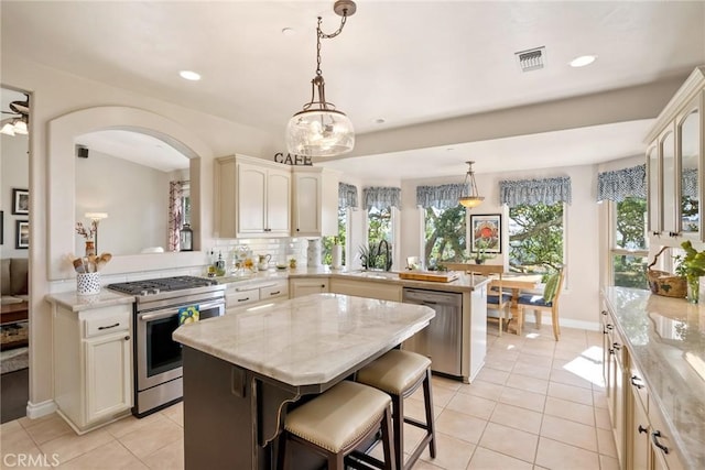 kitchen featuring plenty of natural light, a center island, kitchen peninsula, and appliances with stainless steel finishes