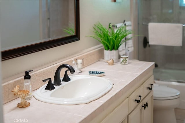 bathroom featuring vanity, toilet, and a shower with shower door