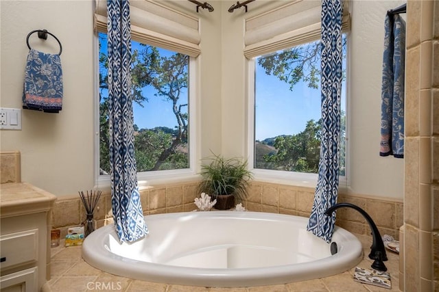 bathroom featuring a relaxing tiled tub and plenty of natural light