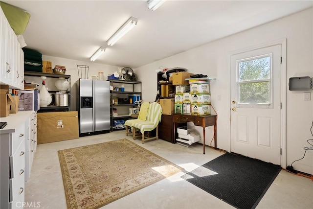 interior space featuring white cabinets and stainless steel fridge