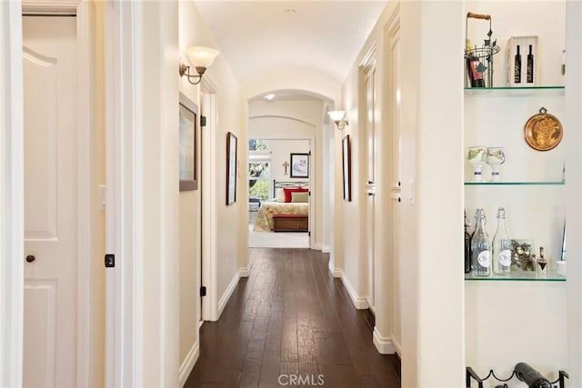 14600 El Monte Rd, Atascadero, CA 93422 - hallway with arched walkways, dark wood-style floors, baseboards, and lofted ceiling
