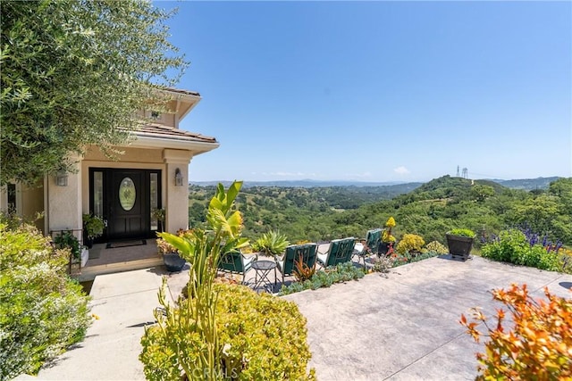14600 El Monte Rd, Atascadero, CA 93422 - entrance to property with stucco siding, a tiled roof, and a view of trees