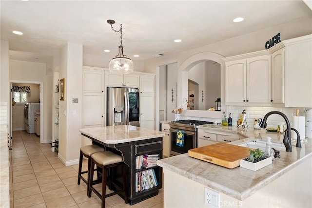 14600 El Monte Rd, Atascadero, CA 93422 - kitchen featuring appliances with stainless steel finishes, light tile patterned floors, a peninsula, recessed lighting, and white cabinetry