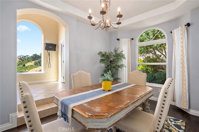 14600 El Monte Rd, Atascadero, CA 93422 - dining room with a chandelier, arched walkways, a raised ceiling, and baseboards