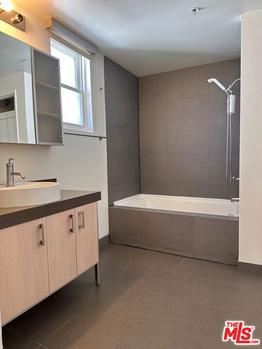 bathroom with vanity and tiled shower / bath combo