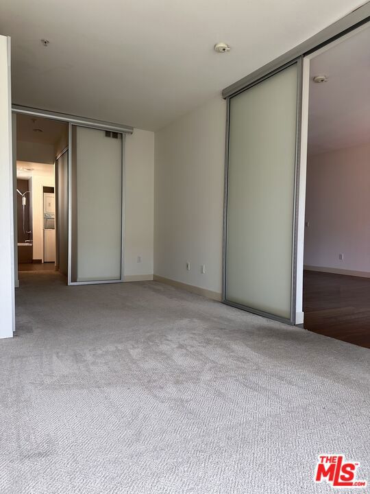 unfurnished bedroom with light carpet and a closet