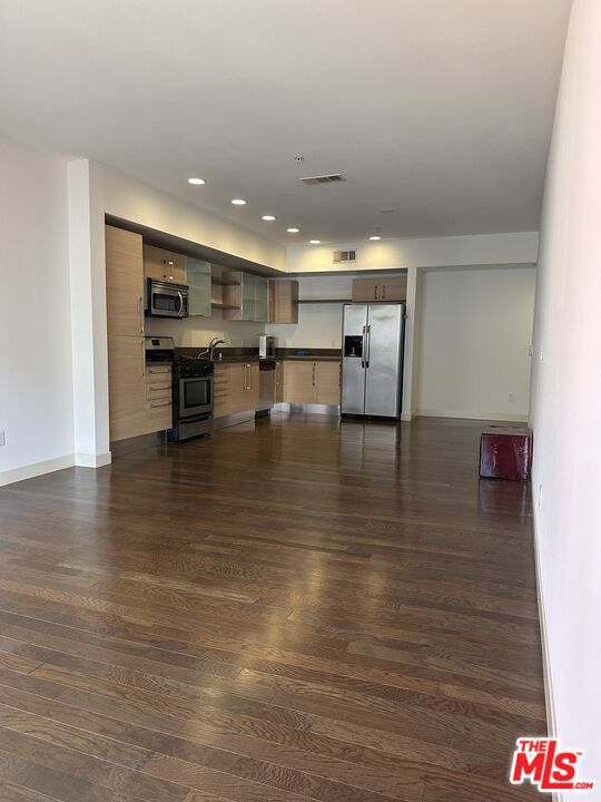 unfurnished living room with dark hardwood / wood-style floors and sink