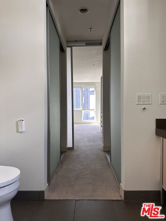 corridor with dark colored carpet