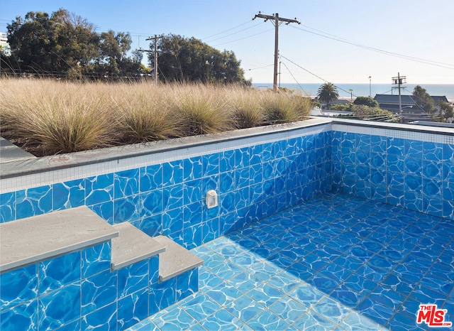 view of pool with a water view