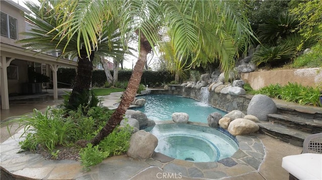 view of swimming pool with pool water feature, cooling unit, an in ground hot tub, and a patio