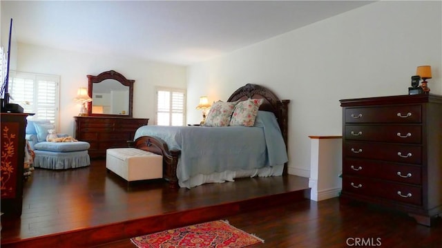 bedroom featuring multiple windows and dark wood-type flooring