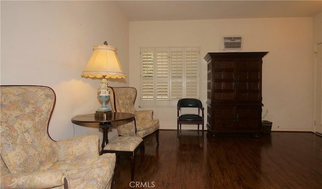 sitting room featuring an AC wall unit and dark hardwood / wood-style flooring