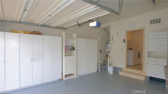 garage featuring washer and clothes dryer and a garage door opener