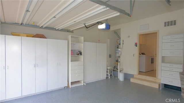 garage featuring washing machine and clothes dryer and a garage door opener