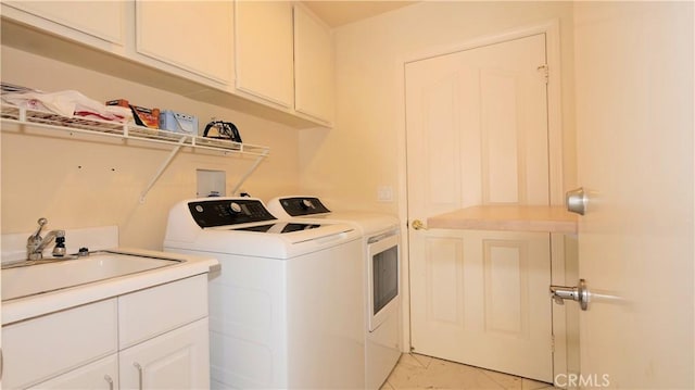 laundry area with cabinets, light tile patterned floors, separate washer and dryer, and sink