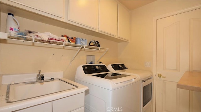 laundry room with washer and clothes dryer, cabinets, and sink