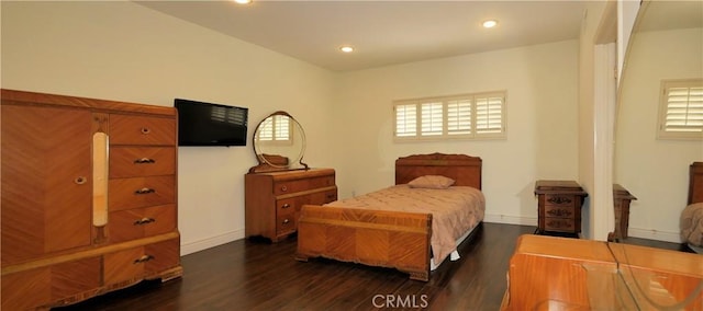 bedroom with multiple windows and dark wood-type flooring