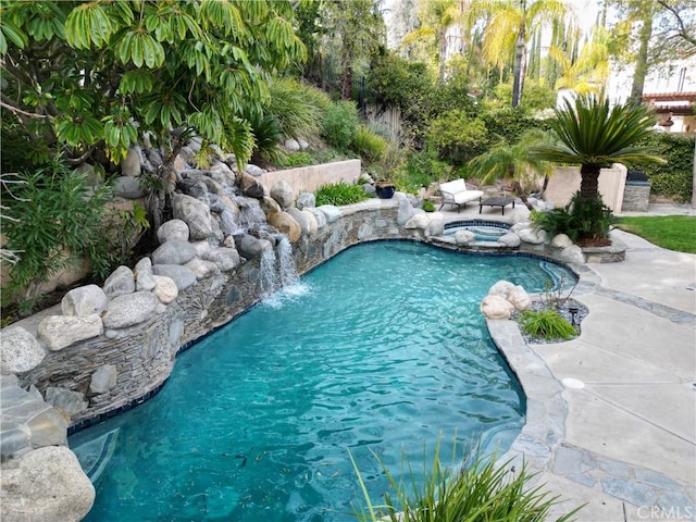 view of pool with an in ground hot tub and pool water feature