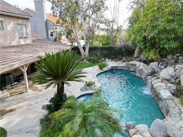 view of swimming pool with pool water feature, a patio, and cooling unit