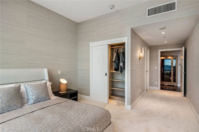 carpeted bedroom with a walk in closet and a closet