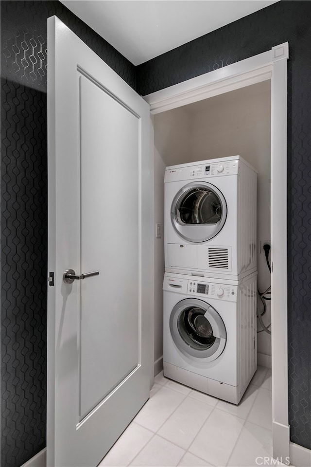 washroom with light tile patterned flooring and stacked washer / dryer