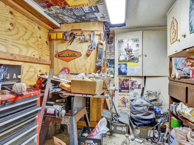 miscellaneous room featuring wooden walls and a workshop area