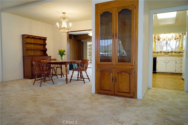 carpeted dining room with sink and a chandelier