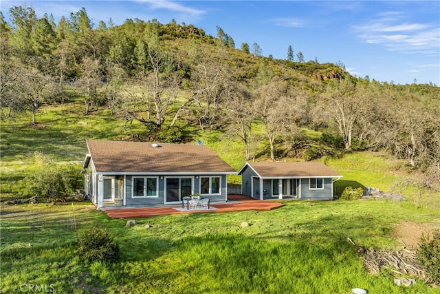 rear view of house with a yard and a deck