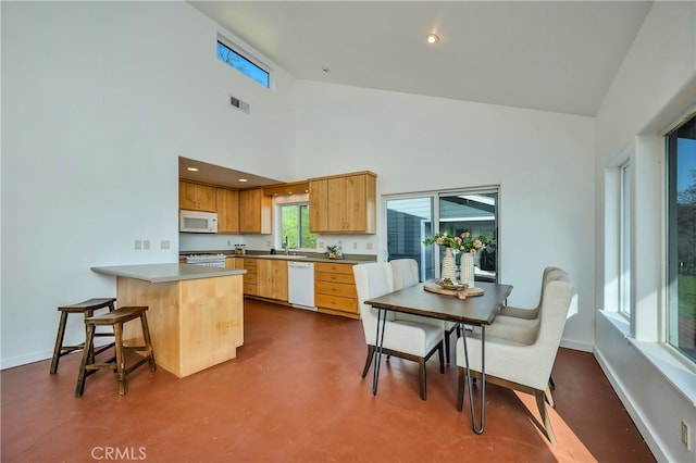 kitchen with sink, kitchen peninsula, high vaulted ceiling, and white appliances