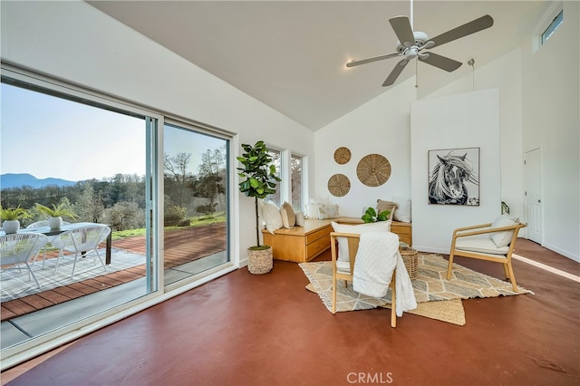 interior space with a mountain view, concrete flooring, high vaulted ceiling, and ceiling fan