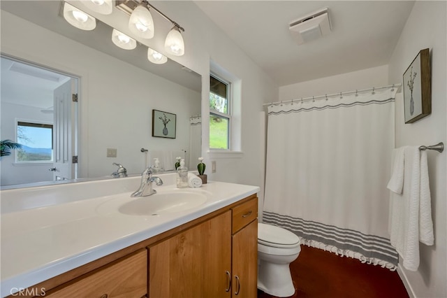 bathroom featuring vanity, a healthy amount of sunlight, toilet, and a shower with shower curtain