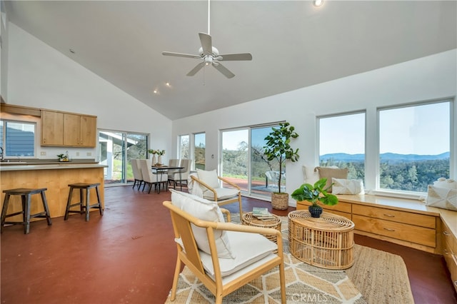 sunroom featuring lofted ceiling, sink, a mountain view, and ceiling fan