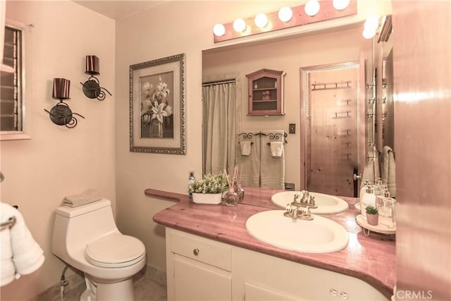 bathroom with tile patterned flooring, vanity, and toilet