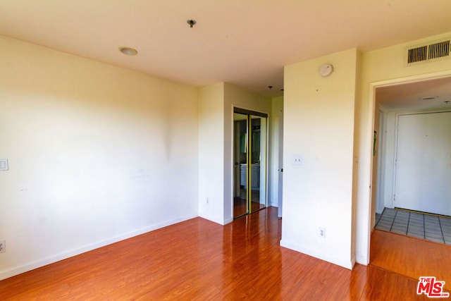 spare room featuring wood-type flooring