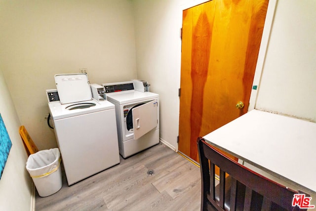 washroom with washing machine and dryer and light hardwood / wood-style floors