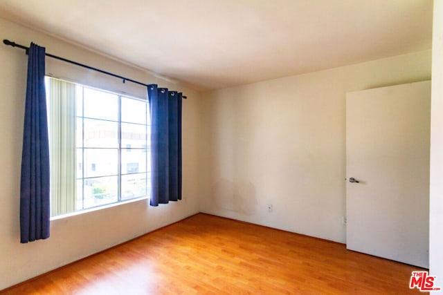 unfurnished room with hardwood / wood-style flooring and a wealth of natural light