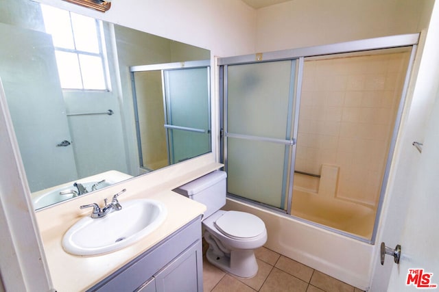 full bathroom featuring vanity, toilet, tile patterned floors, and combined bath / shower with glass door