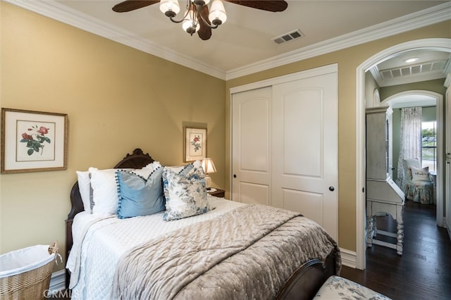 bedroom with a closet, crown molding, dark hardwood / wood-style flooring, and ceiling fan