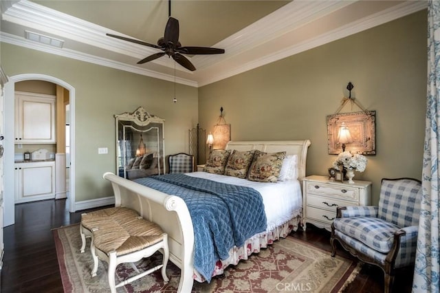 bedroom with visible vents, a ceiling fan, crown molding, dark wood-type flooring, and a raised ceiling