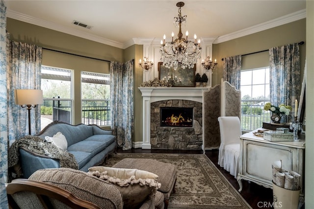 living area with ornamental molding, dark hardwood / wood-style flooring, and a stone fireplace