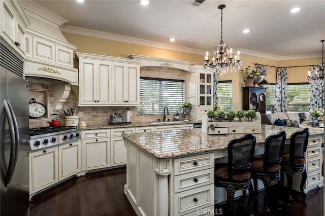 kitchen with appliances with stainless steel finishes, hanging light fixtures, a center island, and a breakfast bar area