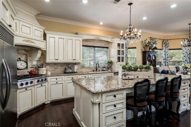 kitchen with a notable chandelier, stainless steel appliances, dark wood-style floors, and a sink